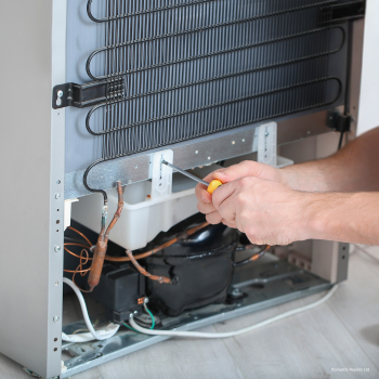 Appliance Repairs by Domestic Repairs Ltd - Engineer repairing a fridge with a screwdriver